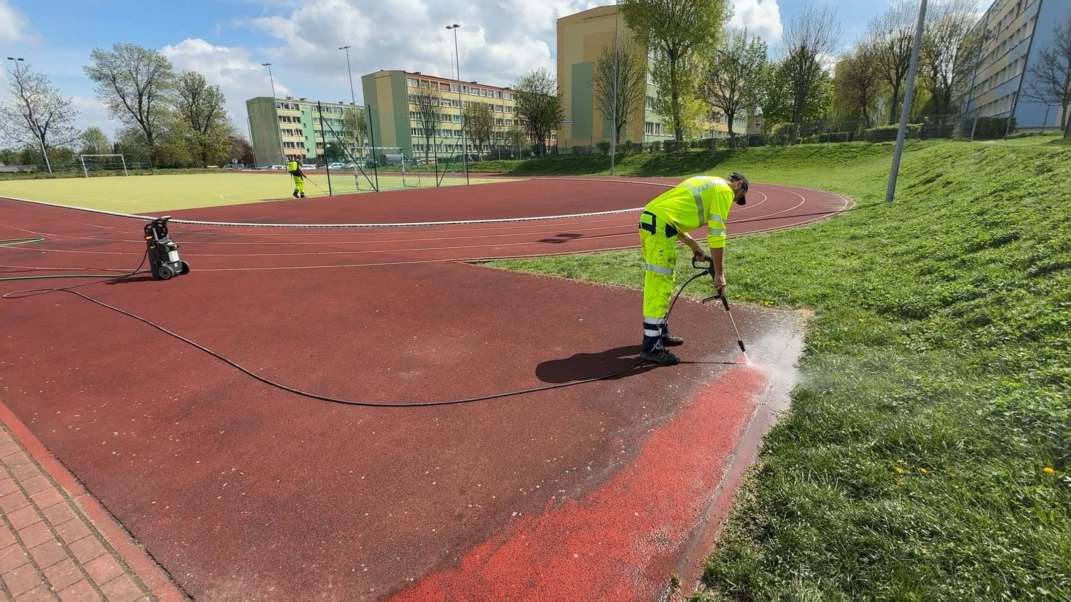 Czyszczenie ciśnieniowe krawędzi bieżni lekkoatletycznej przy skarpie — konserwacja obiektów sportowych