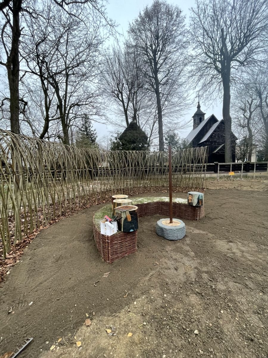 Plecionkowe rabaty i rzeźba przy drewnianym kościele w rezerwacie Kalisz-Zawodzie