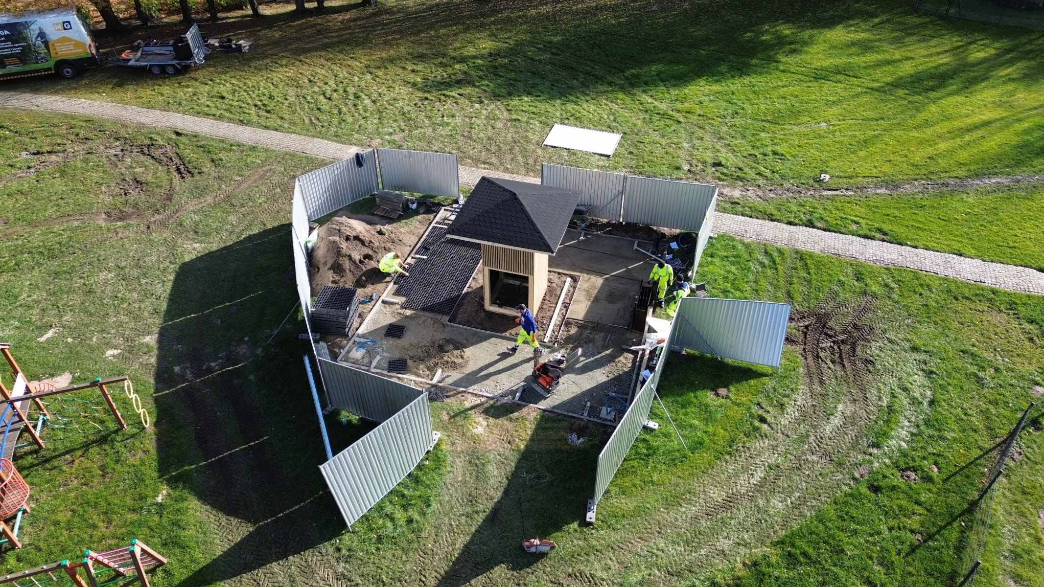 Budowa tężni sonicznej w Raszkowie z lotu ptaka — ogrodzony plac budowy w parku