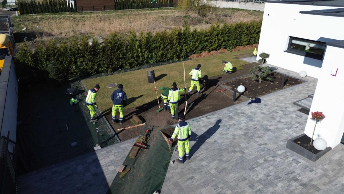 Zakładanie trawnika z rolki przy nowoczesnym domu — brygada GardenProducts na budowie