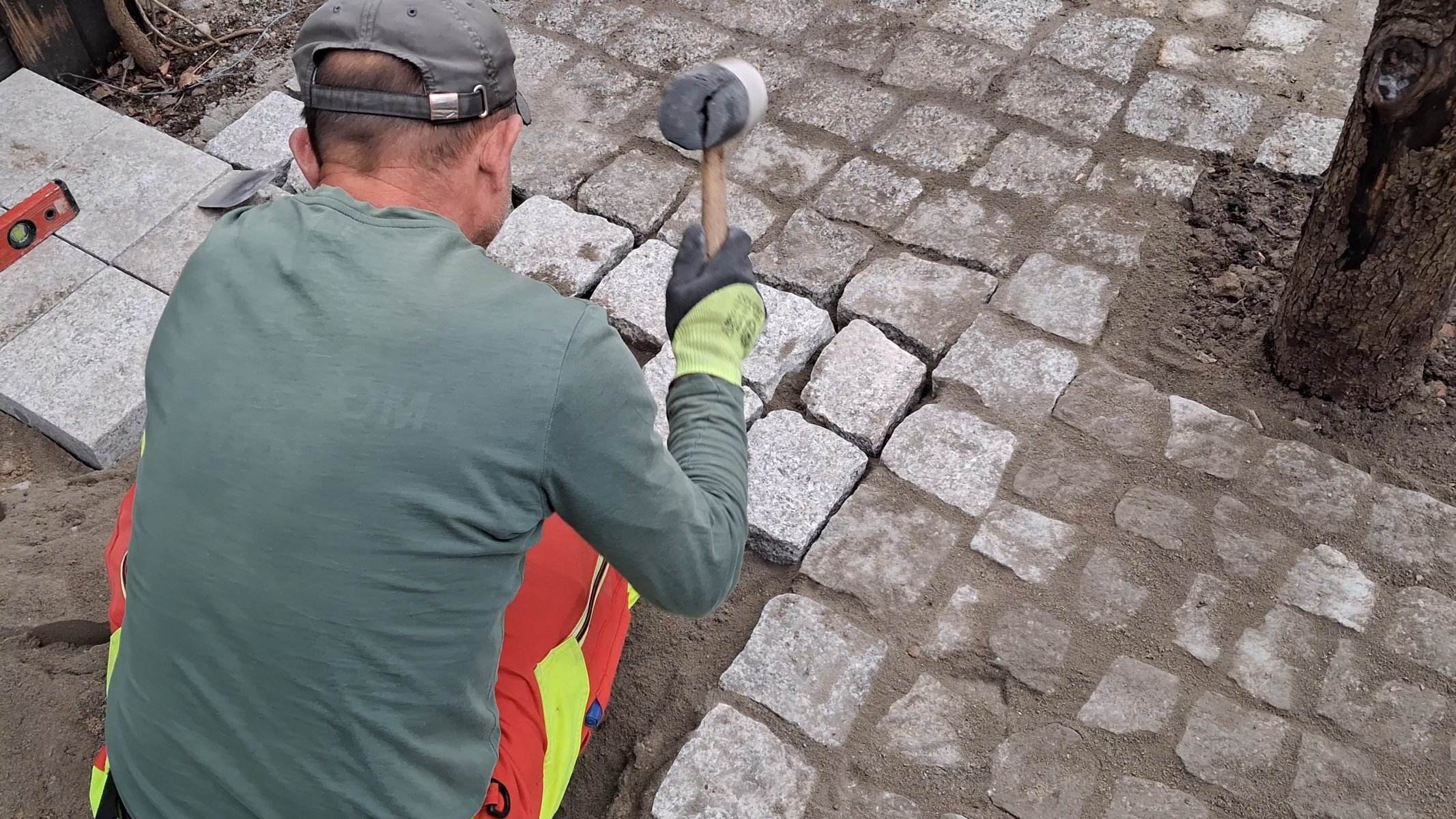 Brukarz układa kostkę granitową gumowym młotkiem — brukarstwo GardenProducts Kalisz