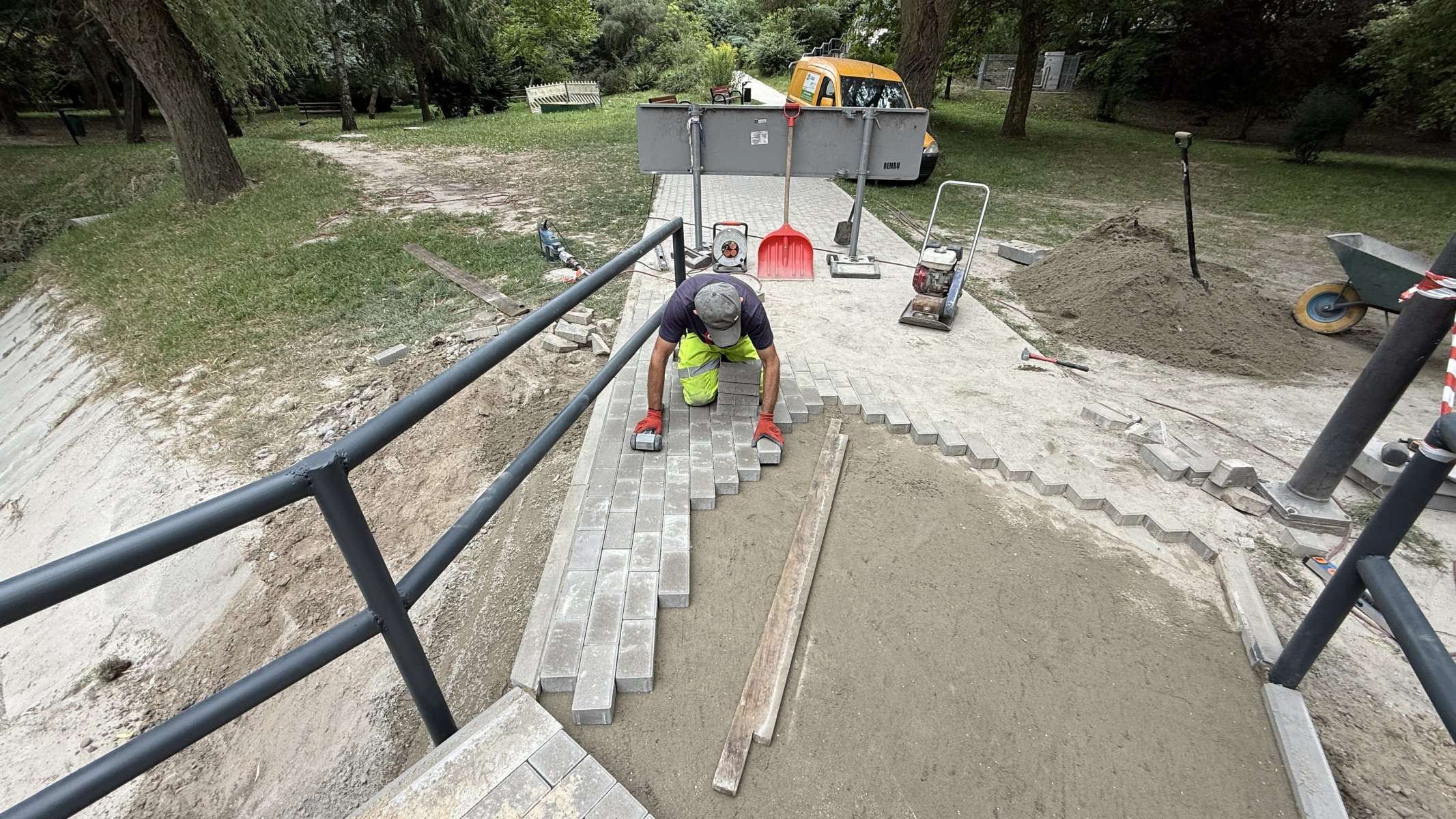 Układanie kostki betonowej na alejce parkowej — brygada brukarska
