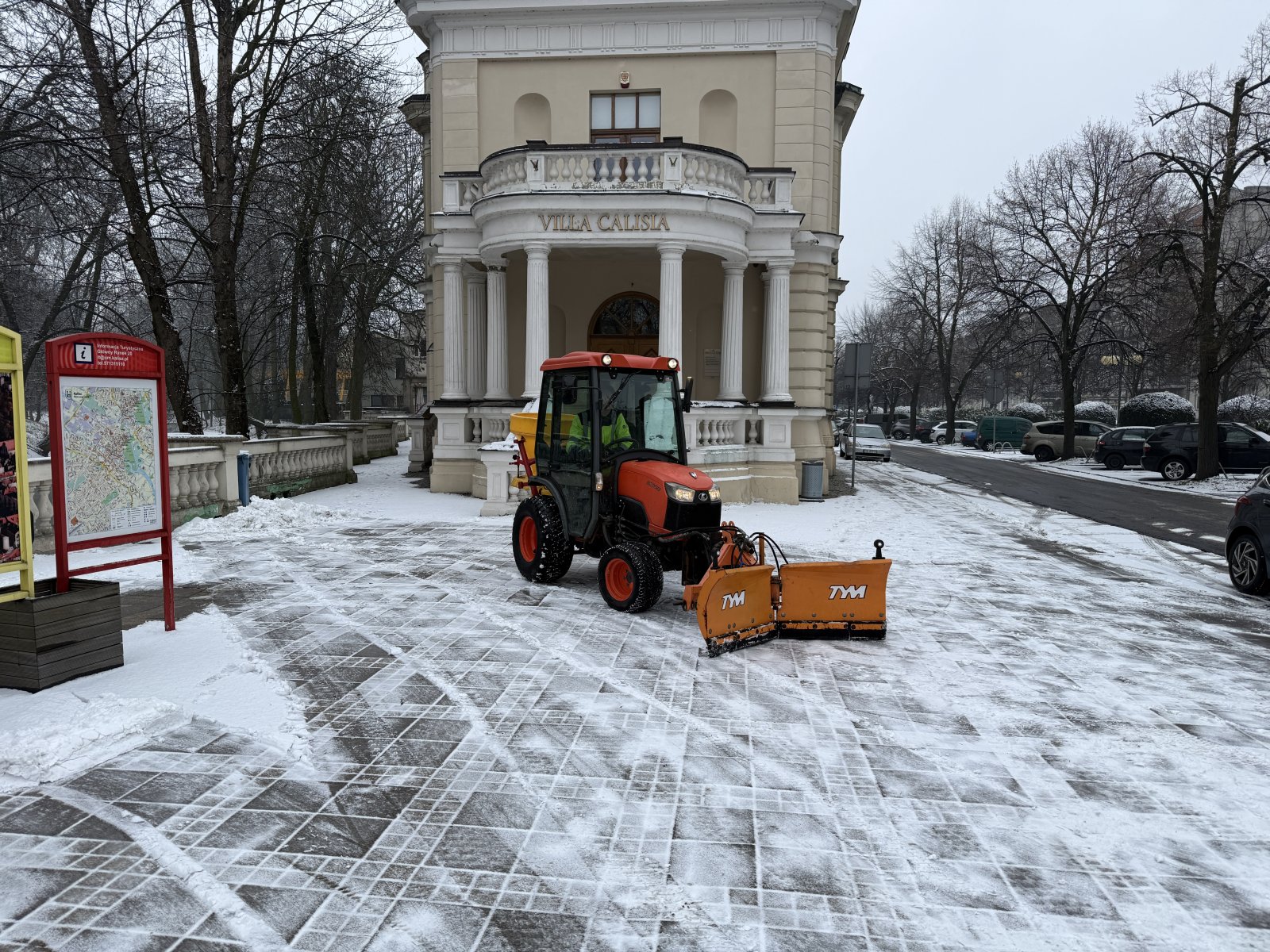 Mikrociągnik z pługiem odśnieża plac przed Villa Calisia